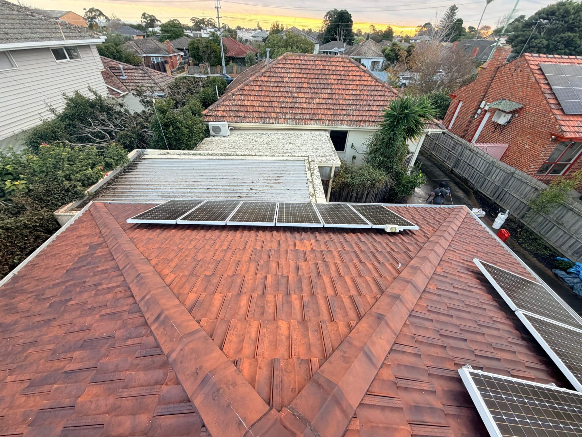 The same terracotta roof after cleaning, natural tile colour, solar panels still in place