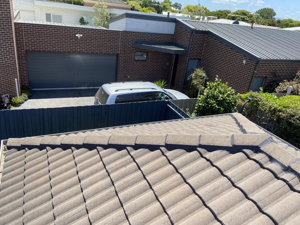 Weathered sandy tiled roof looking across to a neighbouring roof